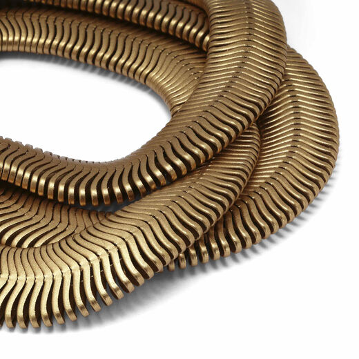 Close up of a gold plated bracelet made up of three strands and a chain extender.
